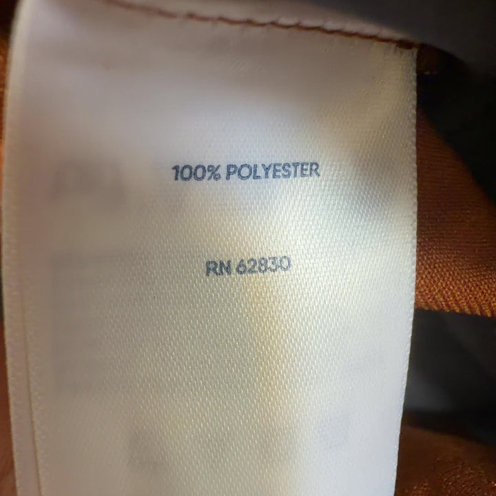 Tag view of orange cropped polyester pants by Lands' End showing fit and length, paired with black crop top