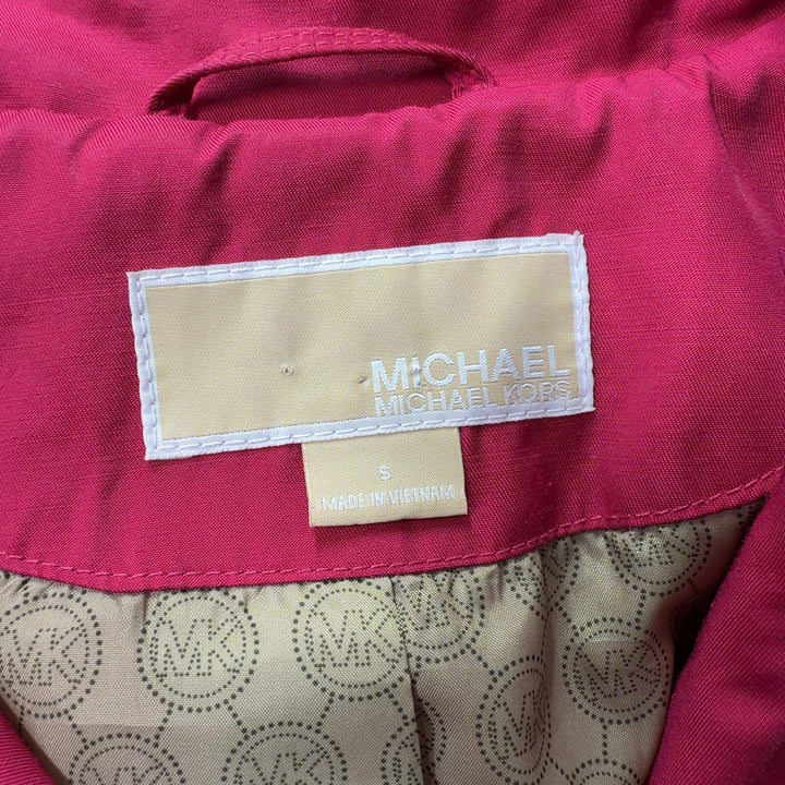 Red double-breasted trench coat by Michael Kors showing back silhouette and A-line cut, back view on model