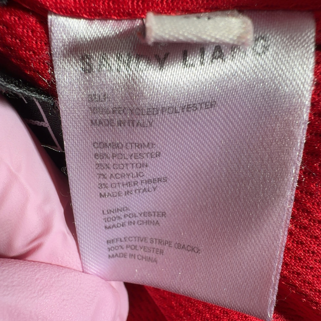 Tag view of red fuzzy jacket showing floral-printed trim detail and oversized silhouette