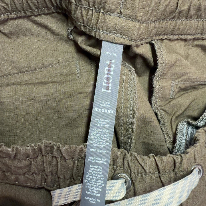 Tag view of brown cargo pants showing relaxed fit and rolled cuff detail