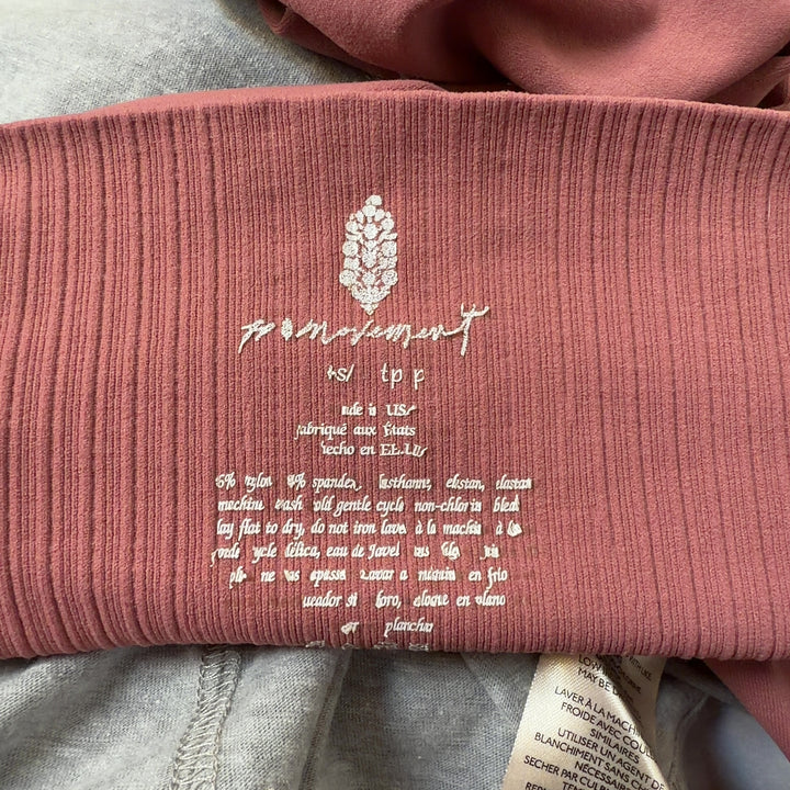 Tag view of pink high-waist ribbed leggings on model, showcasing smooth silhouette and premium fabric quality