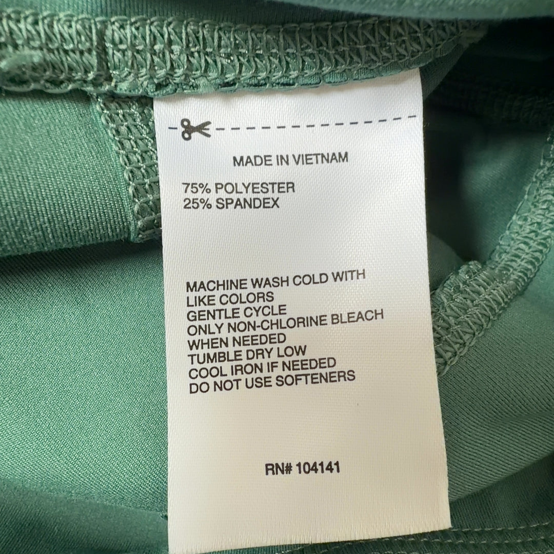 Woman wearing sage green high-waist capri leggings with black sports bra, side view showing fit