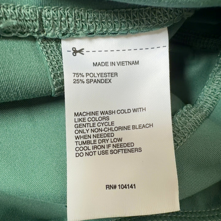 Woman wearing sage green high-waist capri leggings with black sports bra, side view showing fit