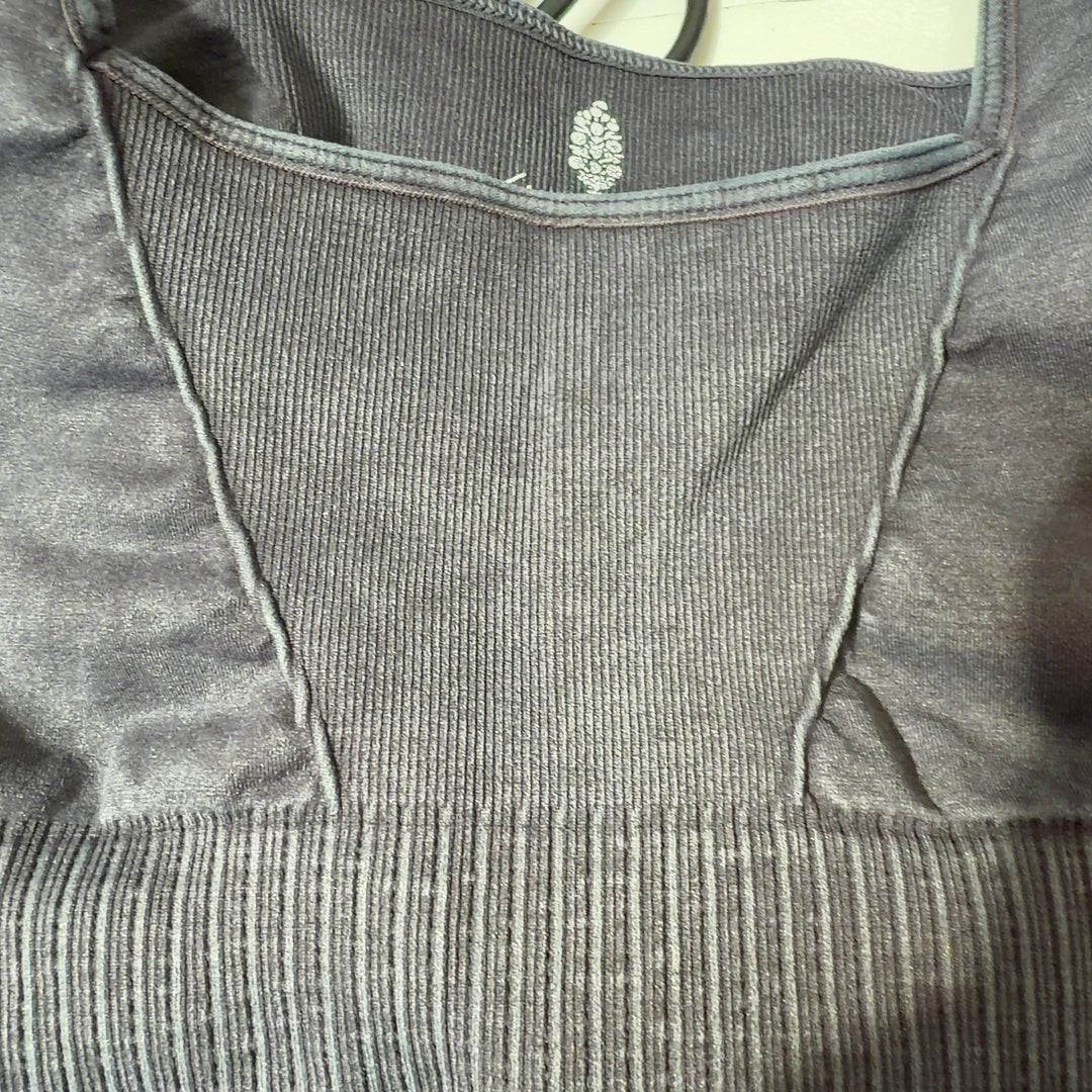 Black ribbed sports bra back view showing supportive design and cropped length on model