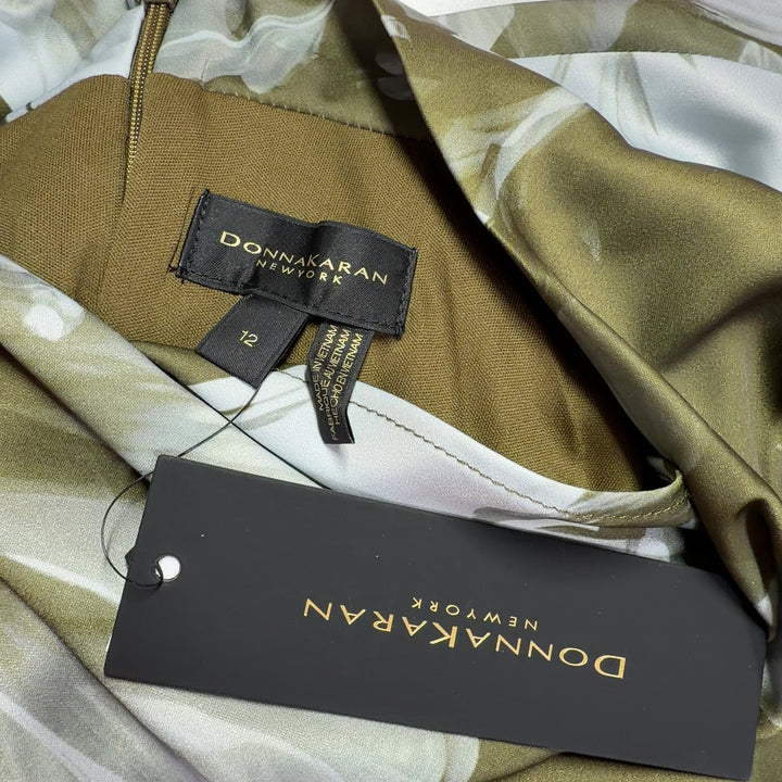 Tag view of olive floral asymmetrical dress showing flowing hemline and sleeveless design