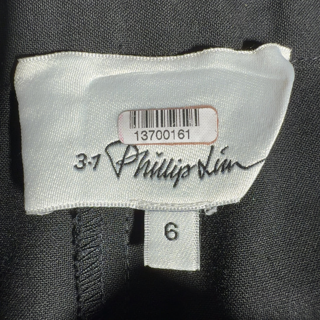 Black paperbag waist pants with tie belt detail, back view showing relaxed fit