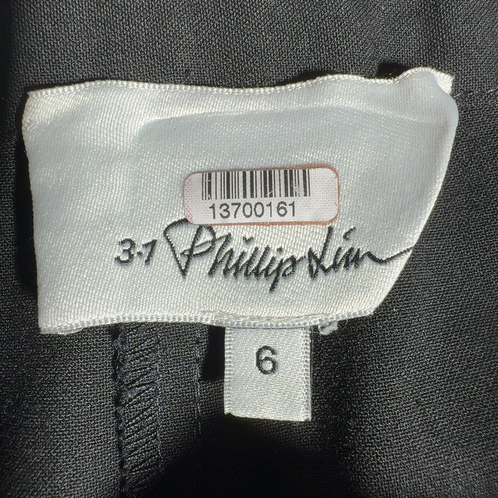 Black paperbag waist pants with tie belt detail, back view showing relaxed fit