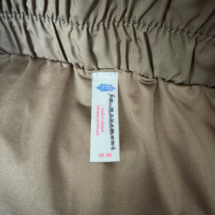 Olive green flared activewear shorts with voluminous leg design, back view