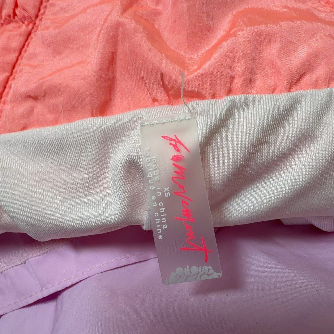 Coral pink ruched athletic shorts back view, showing high-waisted fit and ruching detail