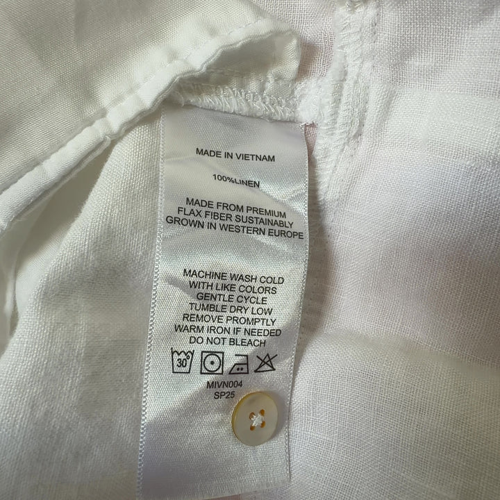 White linen sleeveless button-front dress with side pockets, back view