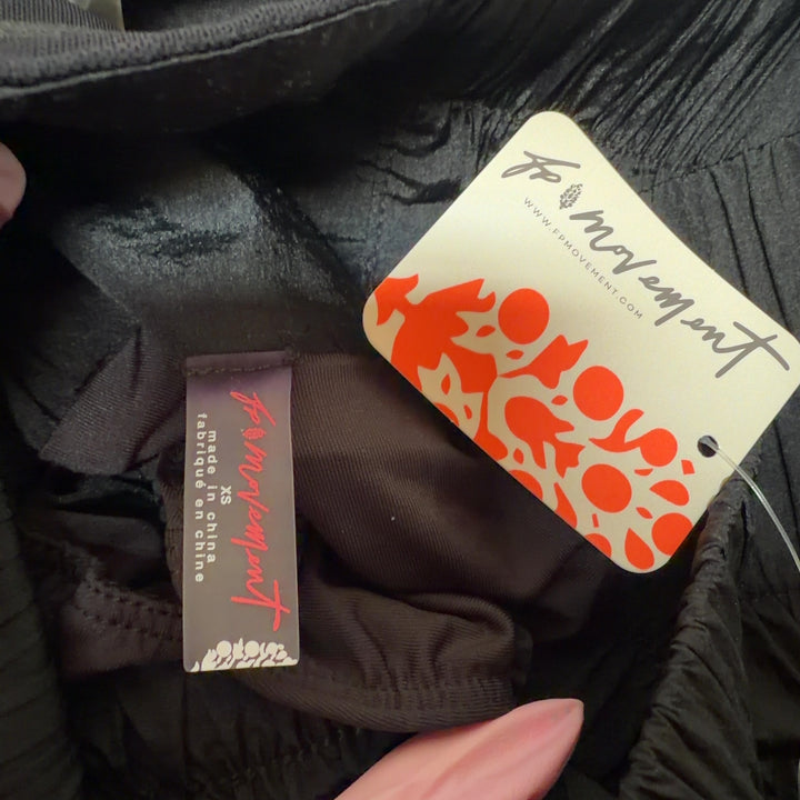 Black and orange colorblock athletic shorts with high-waisted design, side view showing functional orange pocket detail