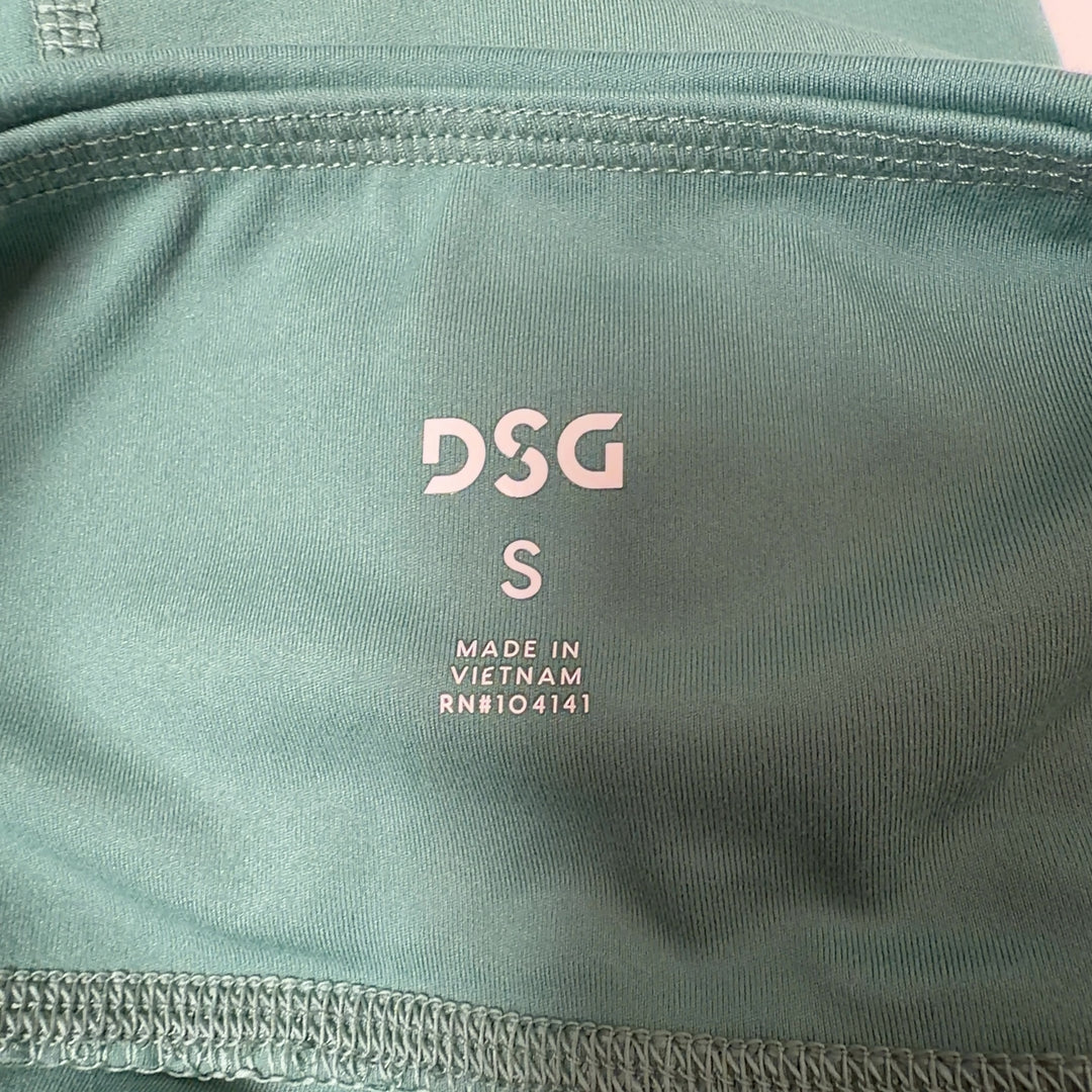Woman wearing sage green high-waist capri leggings with black sports bra, side view showing fit