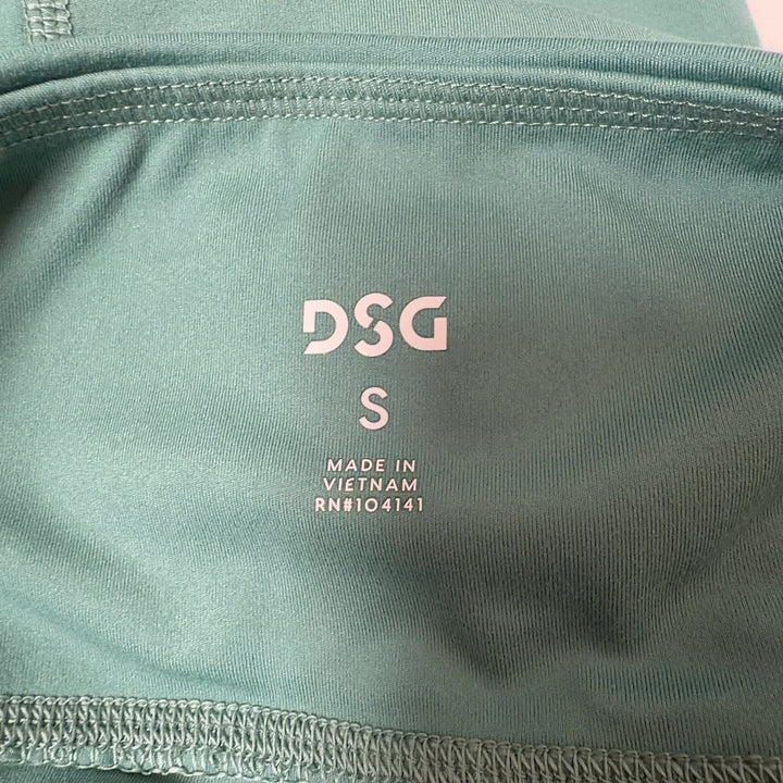 Woman wearing sage green high-waist capri leggings with black sports bra, side view showing fit