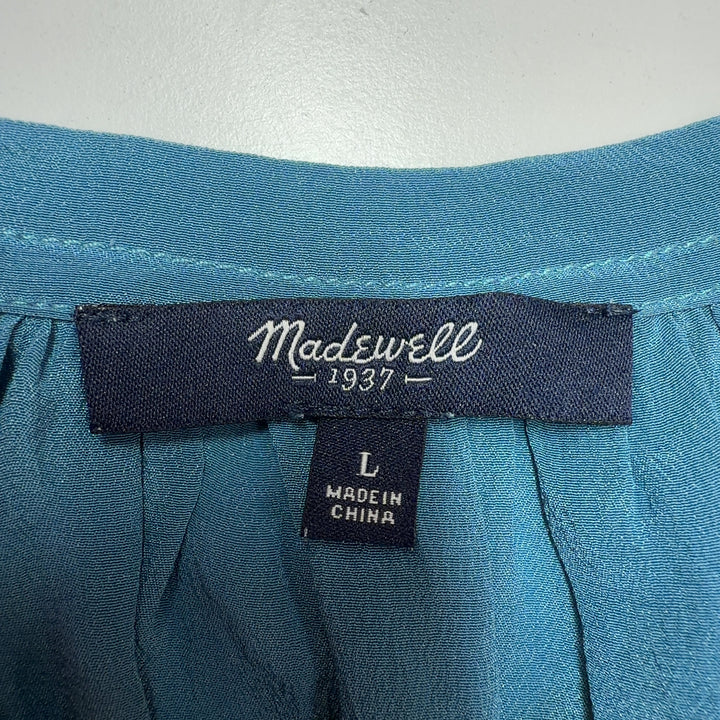 Teal sleeveless top with tiered hem detail, back view on model