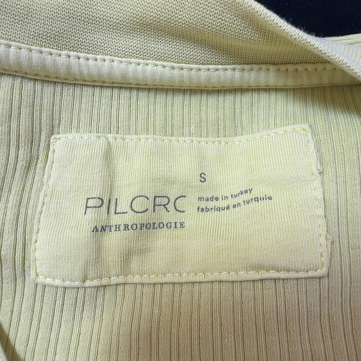 Yellow ribbed henley knit top back view showing fitted silhouette and long sleeves