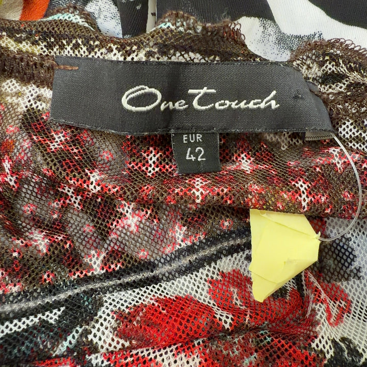 Tag view of rust patchwork knit top showing mixed pattern design and long sleeve construction