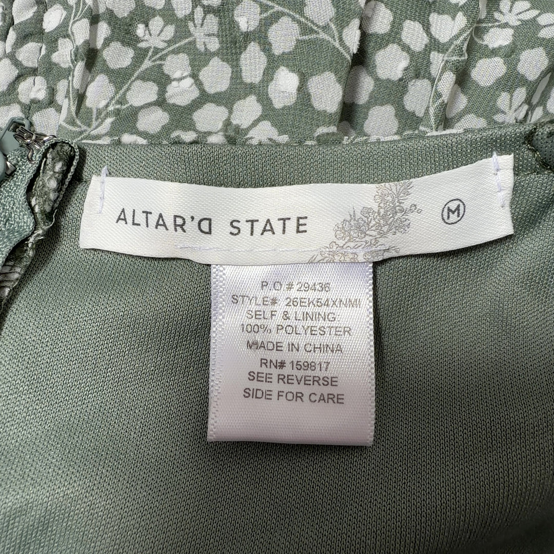 Tag view of sage green floral dress showing gathered bodice and tiered skirt design