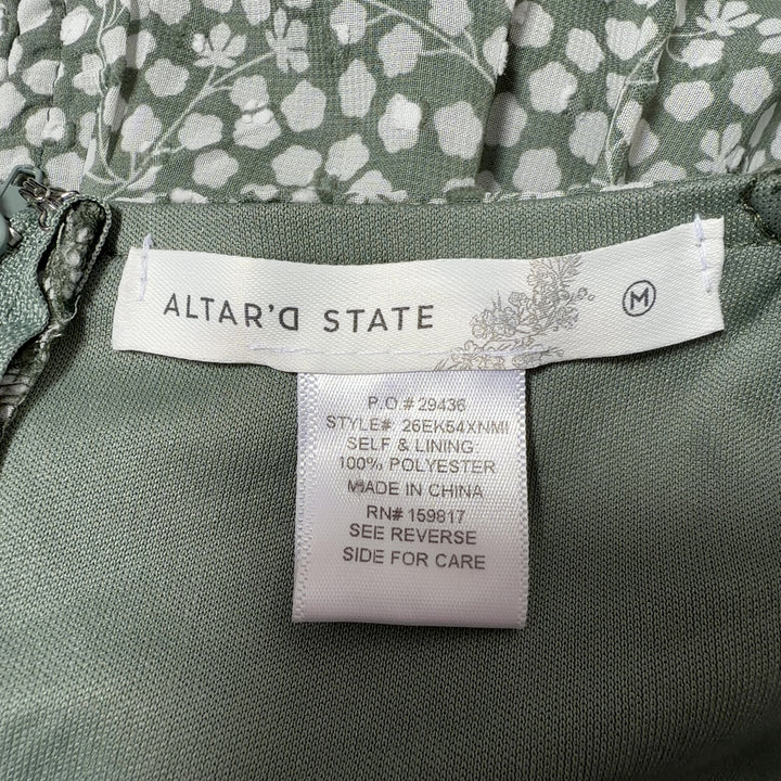 Tag view of sage green floral dress showing gathered bodice and tiered skirt design
