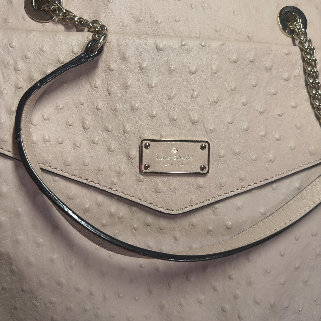 Tag view of cream quilted Kate Spade shoulder tote showing structured design and side pocket detail