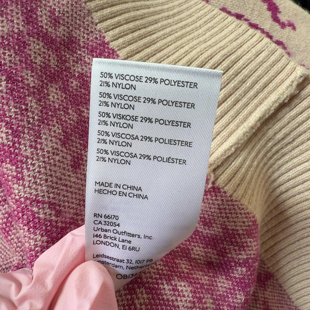 Tag view of pink elephant print knit vest showing sleeveless design and ribbed trim