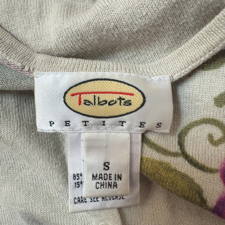 Tag view of cream floral cardigan showing full botanical print design and fitted silhouette