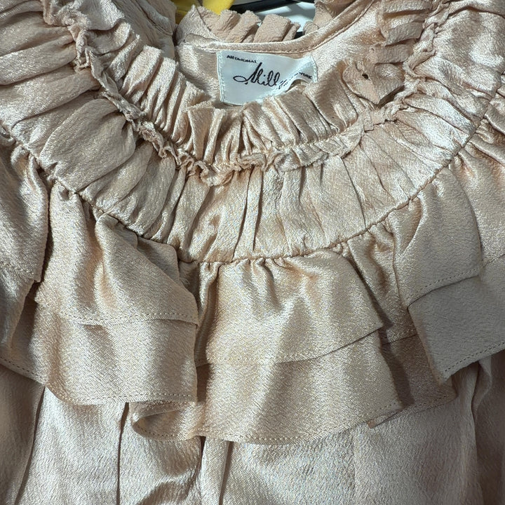 Cream sleeveless blouse with ruffled neckline by Milly, back view