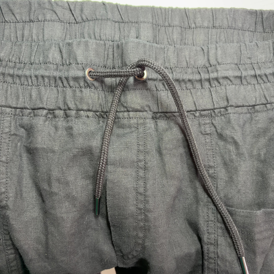 Black drawstring athletic shorts with functional pockets, back view
