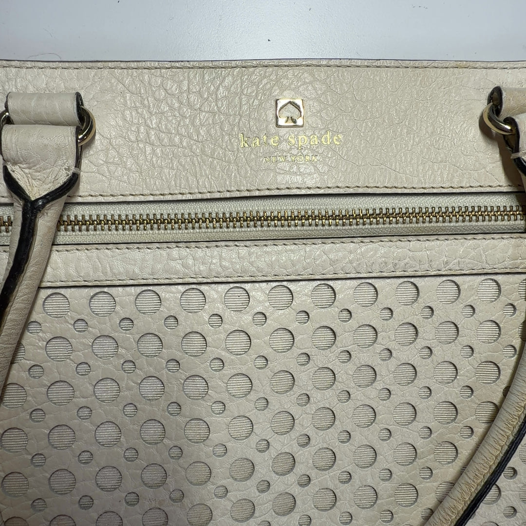 Tag view of cream Kate Spade perforated leather shoulder tote bag showing structured silhouette
