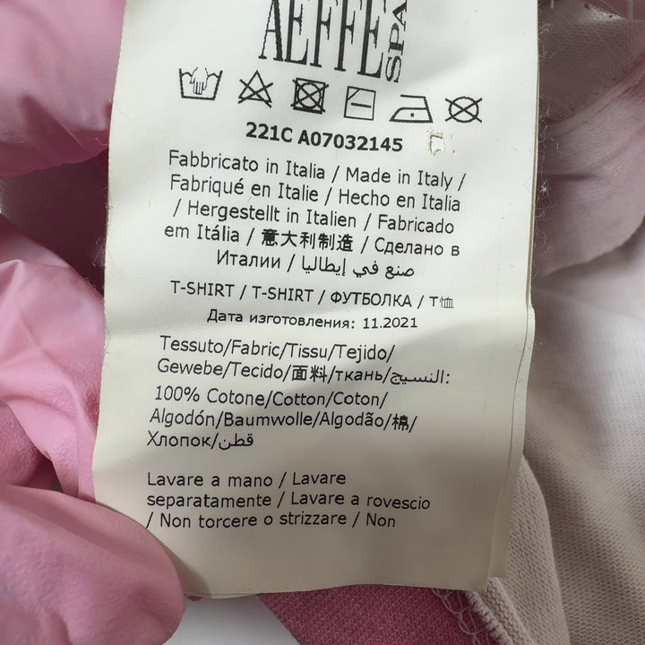 Tag view of pink and white cropped polo shirt showing relaxed fit and cropped length