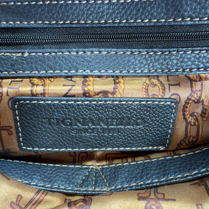 Black leather and canvas Tignanello shoulder tote bag worn on shoulder, side view