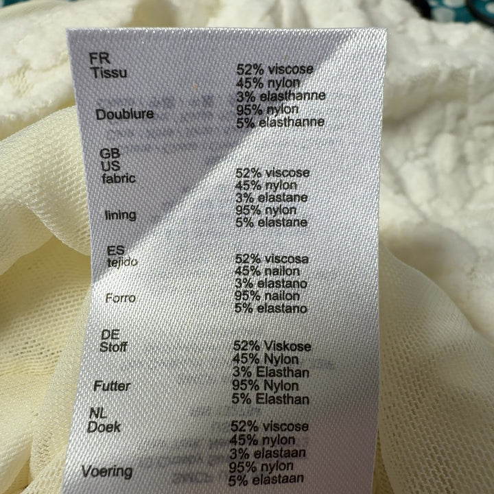 Tag view of Maje cream textured knit puff sleeve top showing fitted design and quality construction