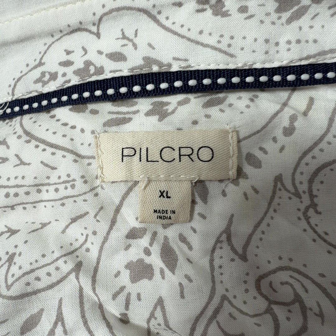 Tag view of cream Pilcro embroidered rayon shirt showing scattered whimsical motifs and button-up closure