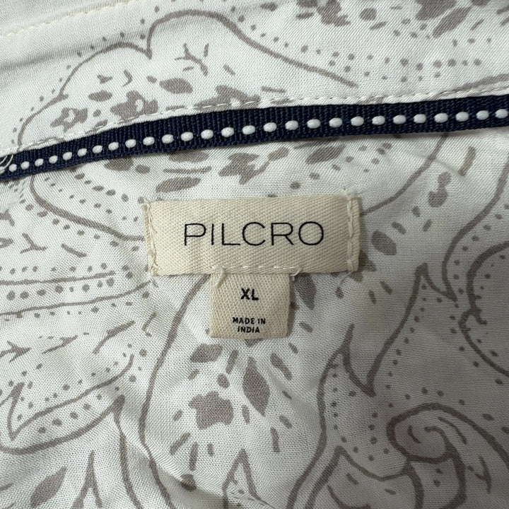 Tag view of cream Pilcro embroidered rayon shirt showing scattered whimsical motifs and button-up closure