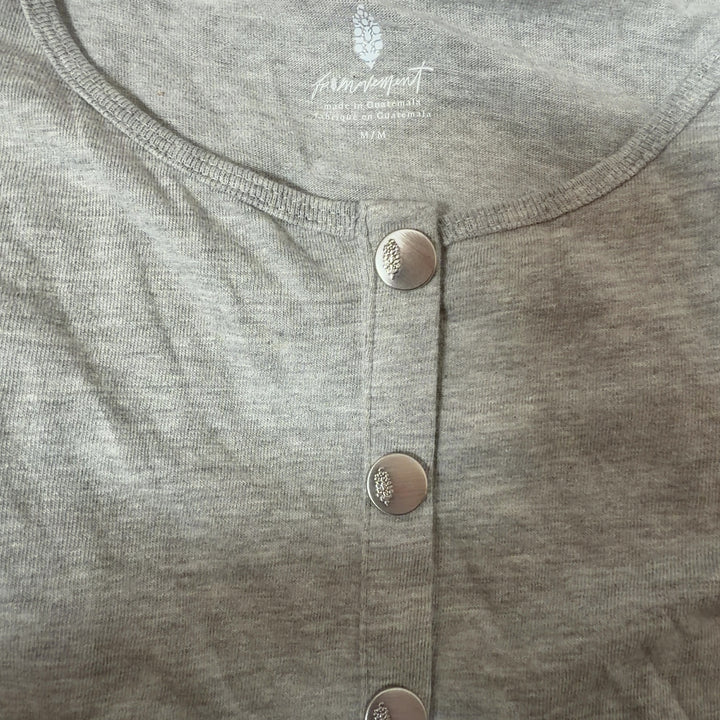 Beige button-front short sleeve top, back view on model showing relaxed fit