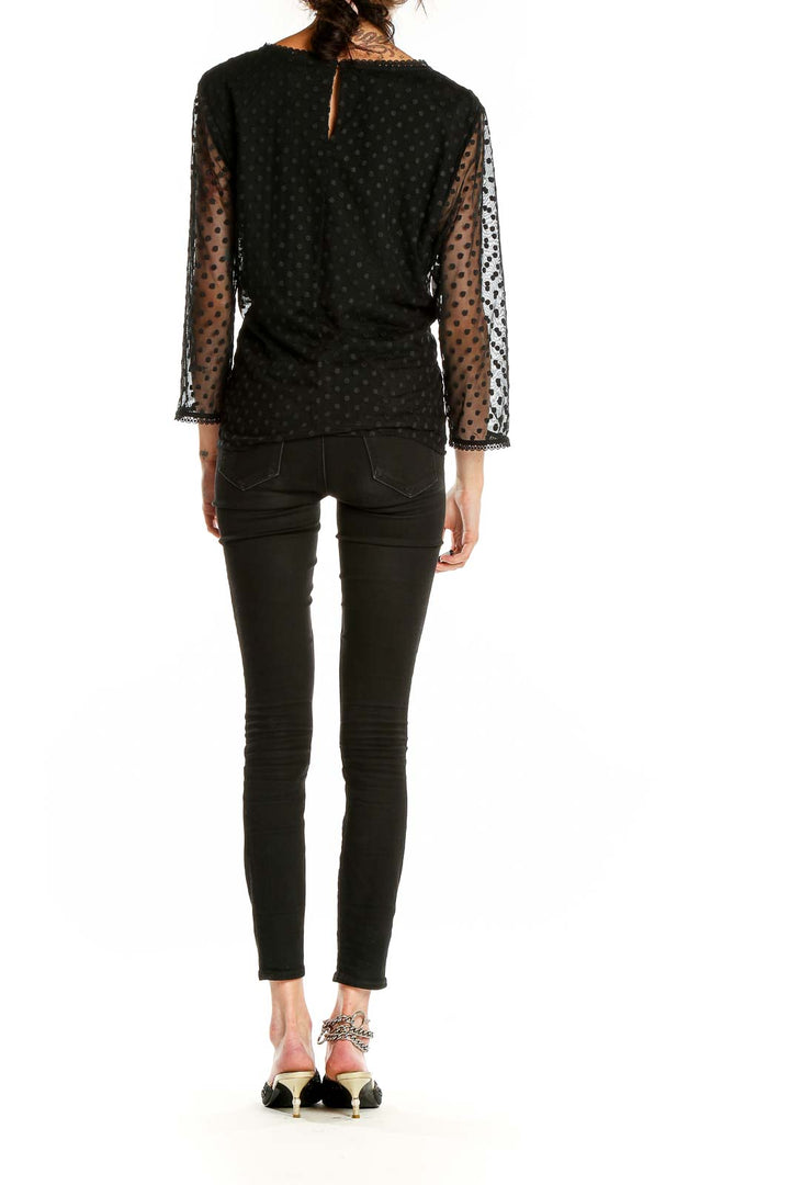 Back view of Boden black top showing polka dot sheer sleeves and relaxed fit