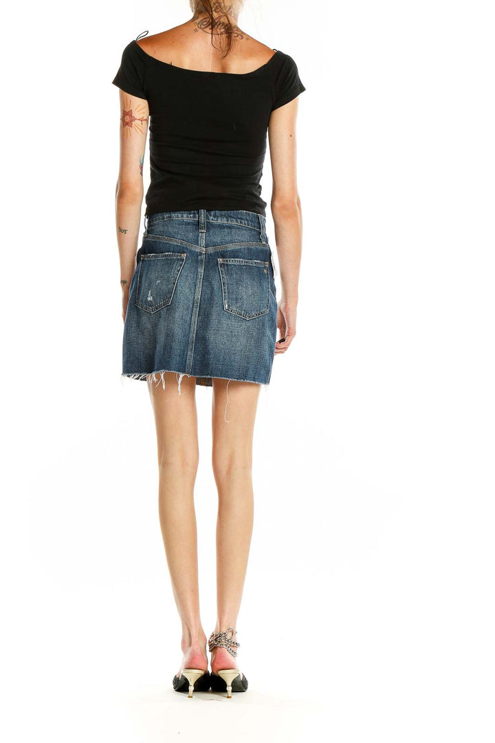 Side view of model wearing Madewell blue denim mini skirt with black top