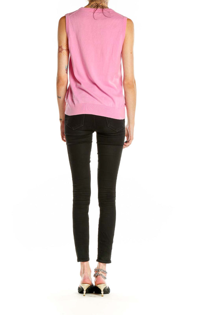 Side view of J.Crew pink sleeveless knit top paired with black pants