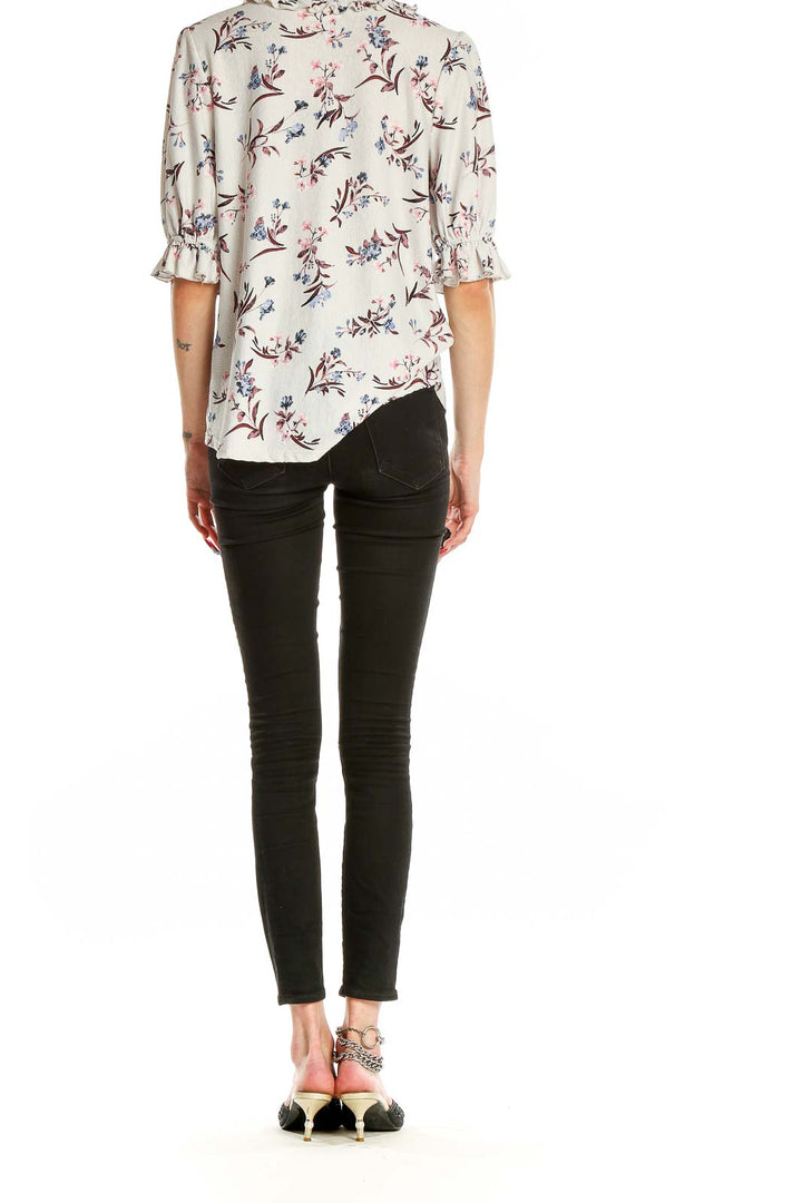 Back view of Melloday white floral print blouse on model with black pants