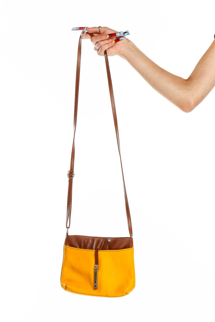 Front view of yellow canvas crossbody bag with brown leather trim