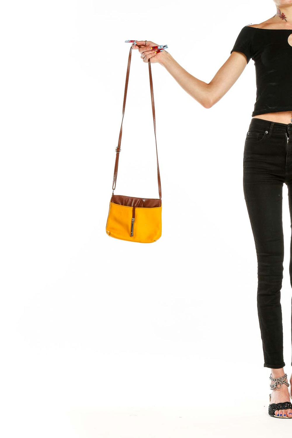 Front view of yellow canvas crossbody bag with brown leather trim