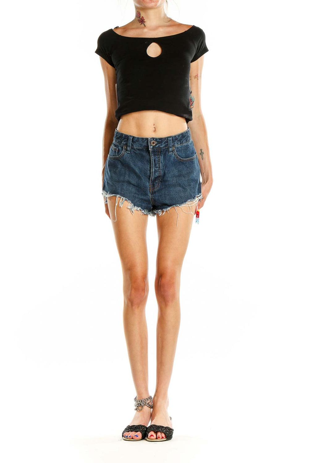 Front view of Free People blue denim distressed high-waisted shorts on model