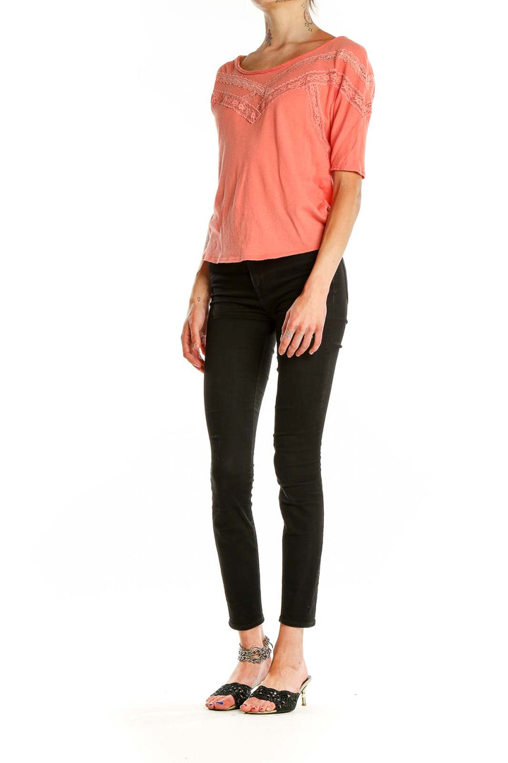 Front view of coral Free People cotton top with lace trim detailing