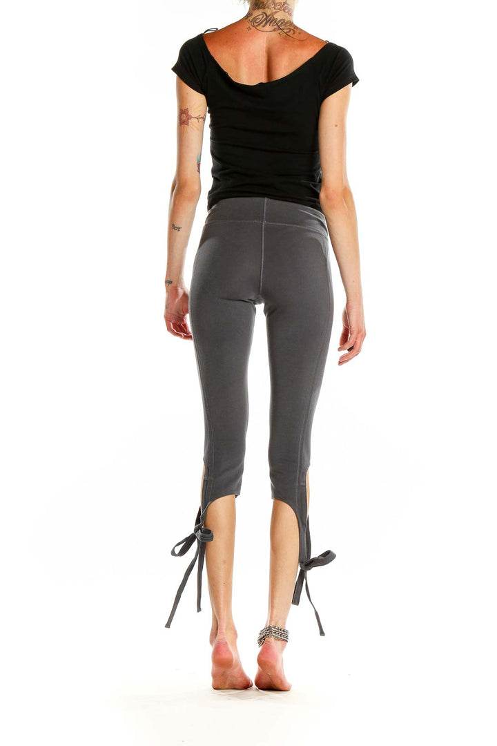 Back view of gray capri leggings showing tie-ankle design and fitted silhouette