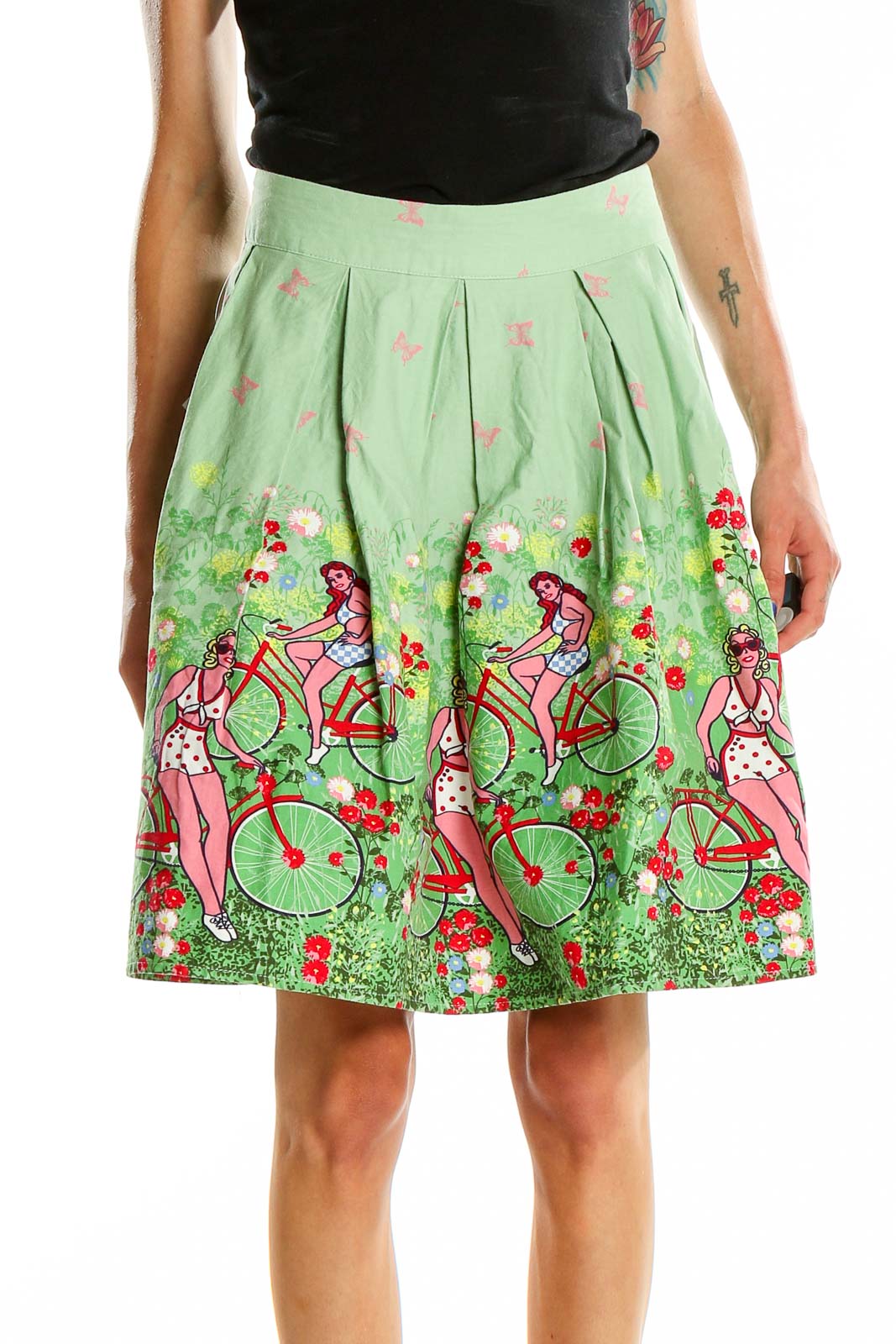 Front view of green pleated skirt with bicycle and floral print