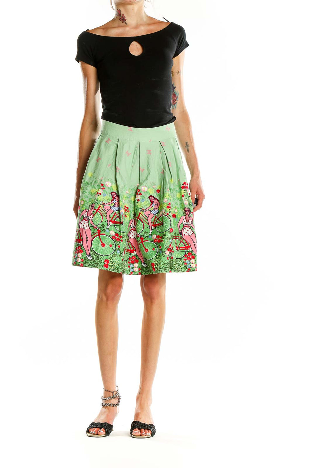 Front view of green pleated skirt with bicycle and floral print