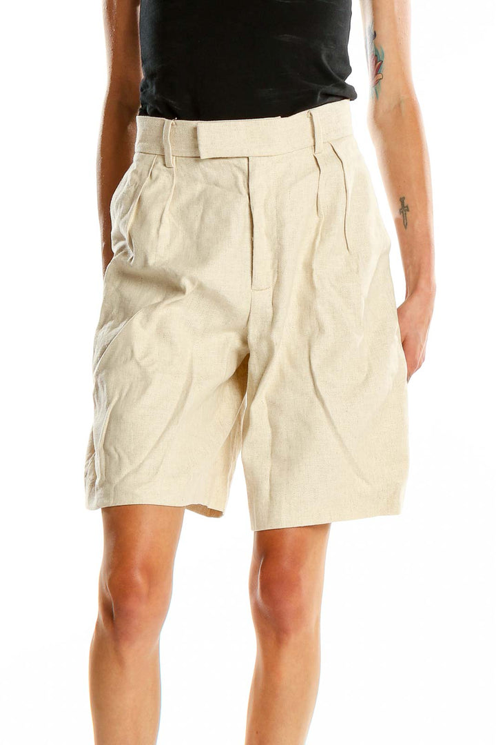 Front view of Banana Republic beige pleated Bermuda shorts on model