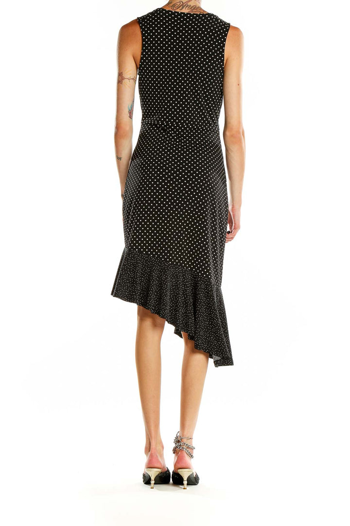 Back view of Leota black polka dot dress showing asymmetric ruffle detail