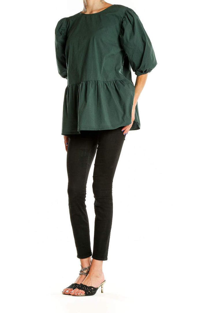 Front view of Eloquii forest green puff sleeve peplum top on model