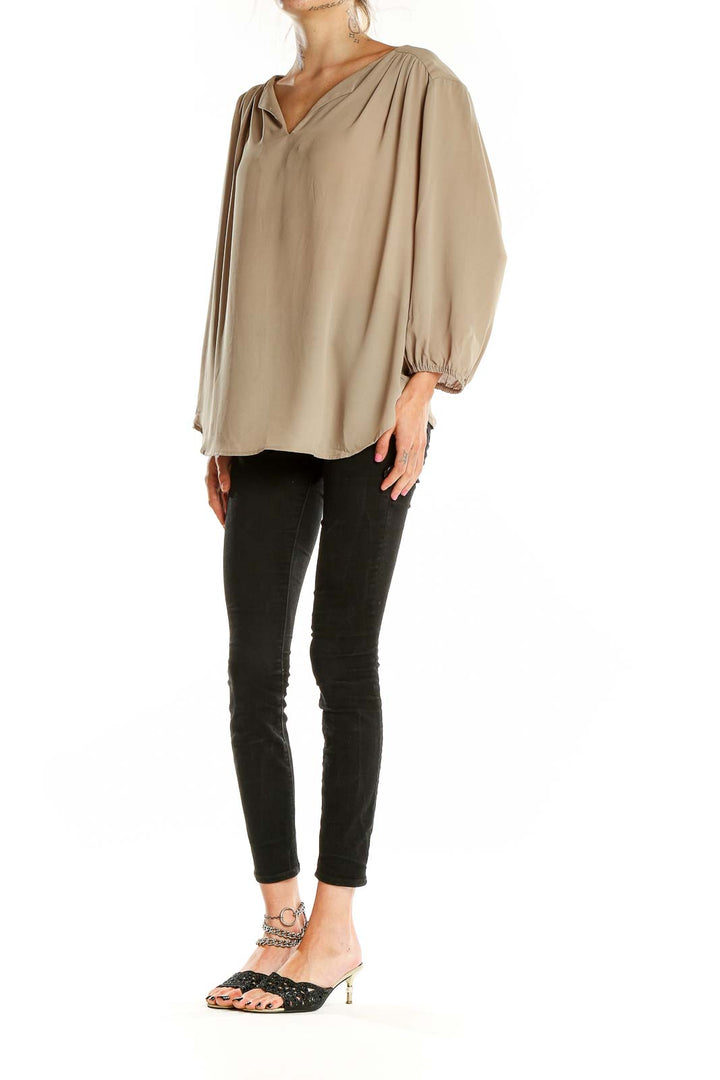 Front view of beige Pleione V-neck blouse with flowy sleeves