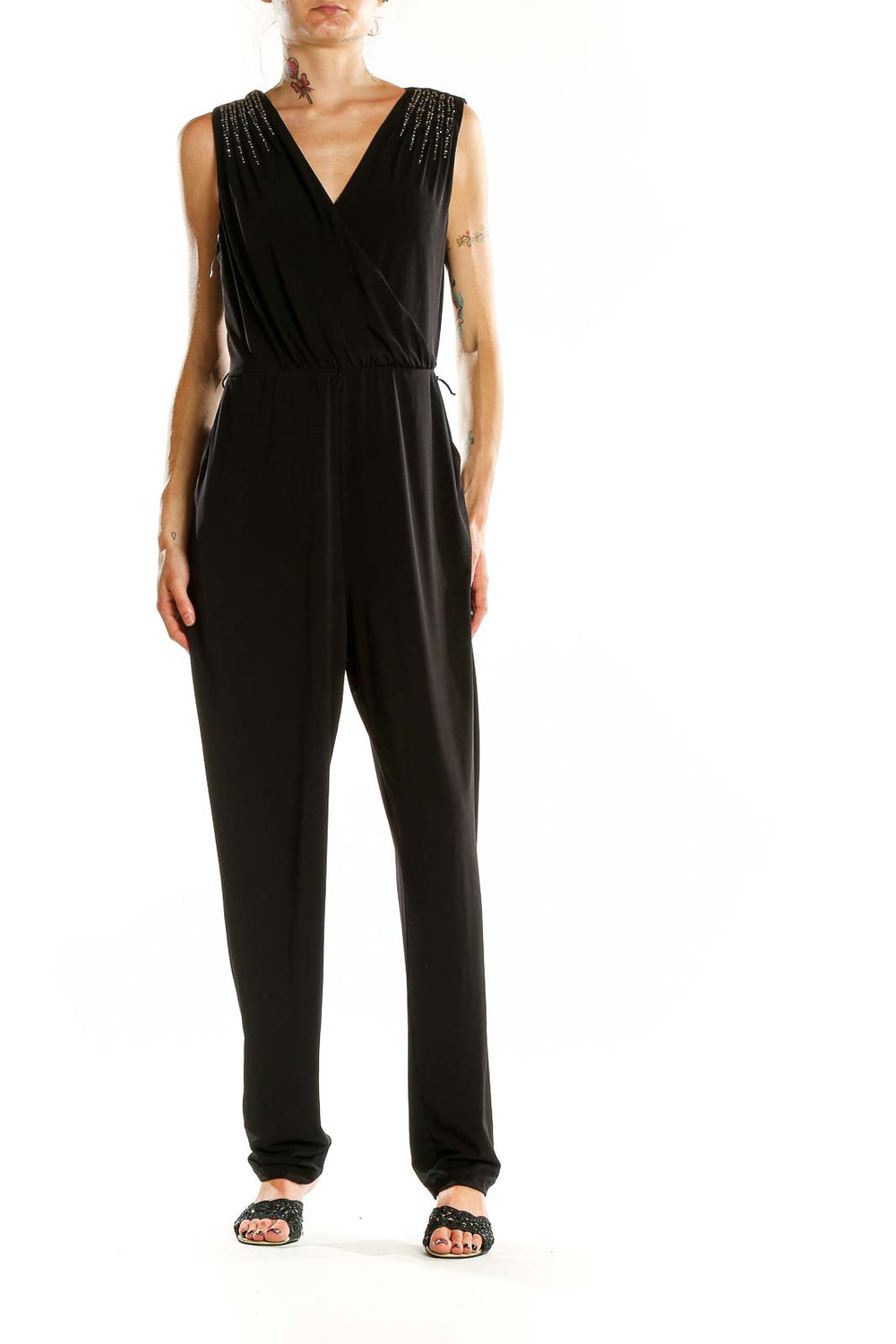 Front view of Calvin Klein black jumpsuit with V-neck and embellished shoulders